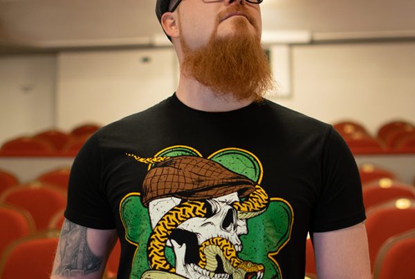 Dwight trägt das Shamrock Snake T-Shirt.